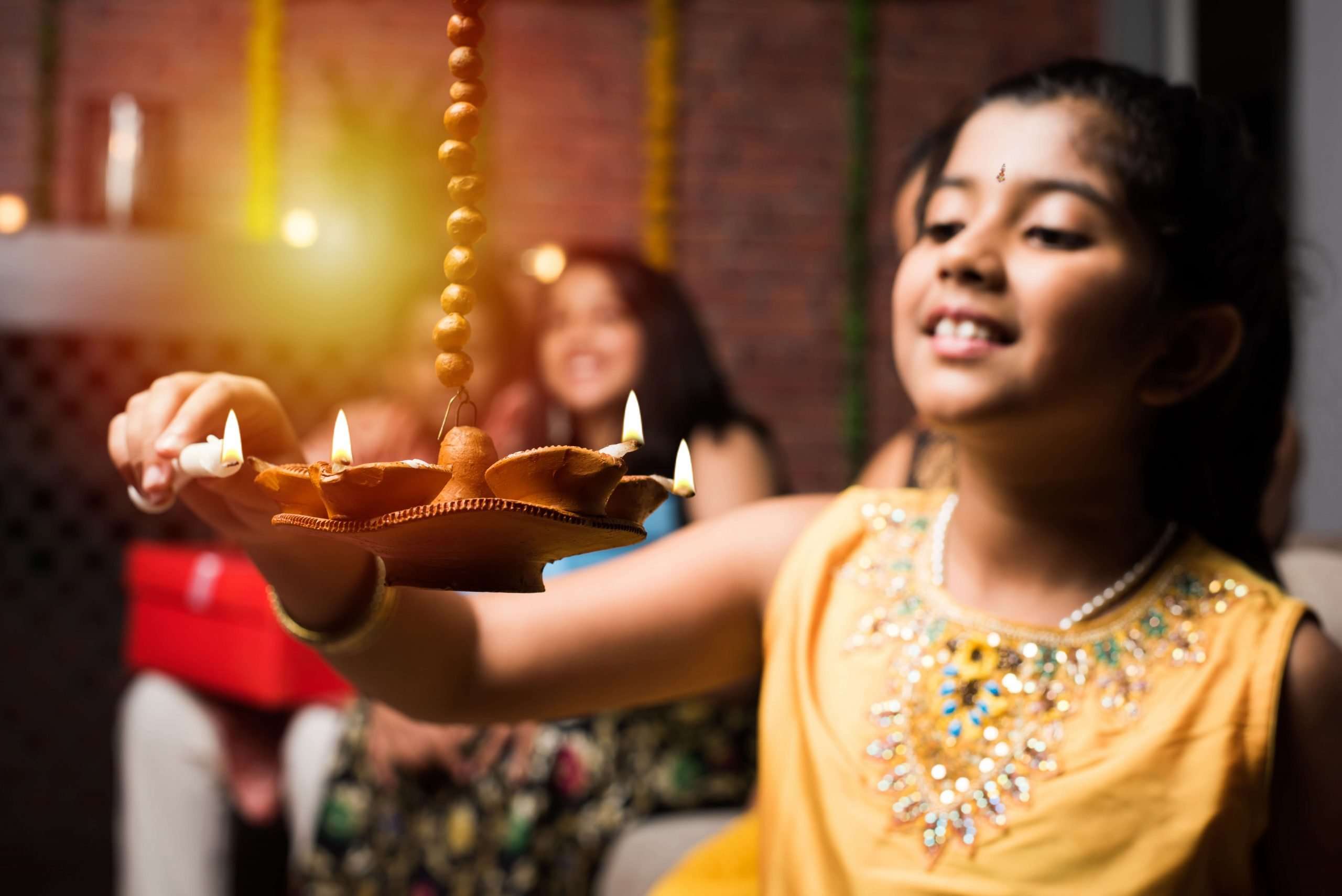 Indian girl holds clay oil lamps