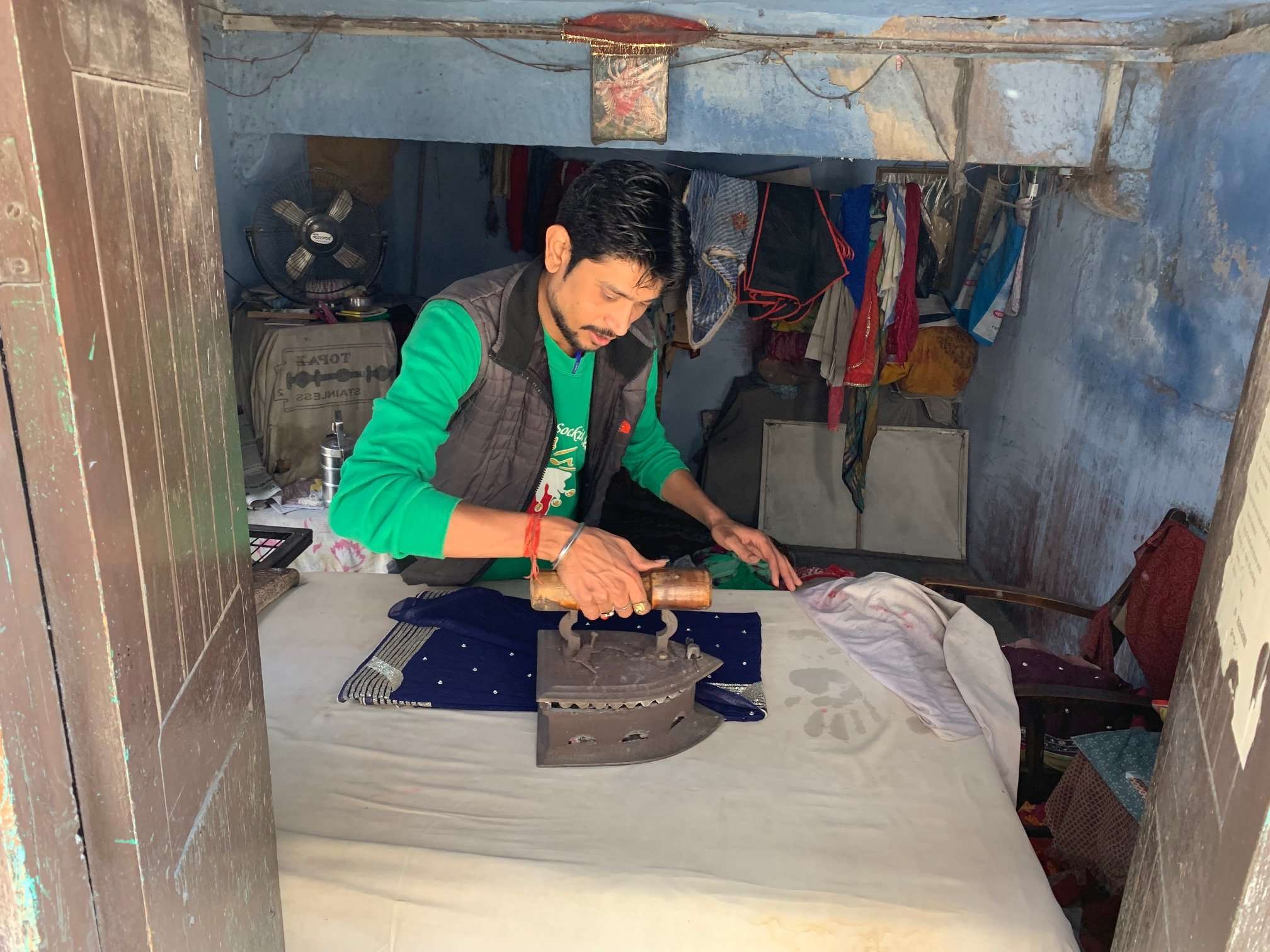 man pressing clothes in rajasthan market